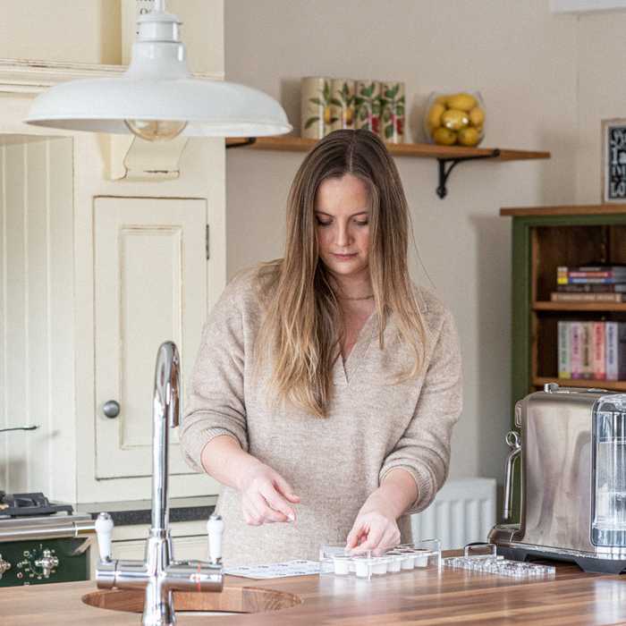 Lady filling coffee pods with ground coffee beans